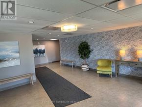 Guelph (Grange Road) condo for rent - A realtor's office with a grey carpet and a yellow chair.