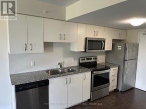 Guelph (Grange Road) condo for rent - A kitchen with white cabinets and a granite countertop.