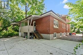 Guelph (Downtown) fourplex for rent - A red brick house with a white roof and a driveway in front.
