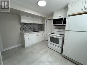 Guelph (Downtown) fourplex for rent - A kitchen with white appliances and cabinets.