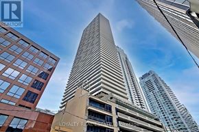Toronto (Mount Pleasant West) condo for rent - A tall building with the words "Loyalty Real" on it is in the foreground of a cityscape.