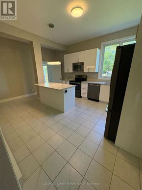 Ottawa multi-family for rent - A kitchen with white tiled floors and a large island.