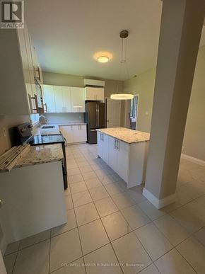 Ottawa multi-family for rent - A kitchen with white cabinets and a marble island.
