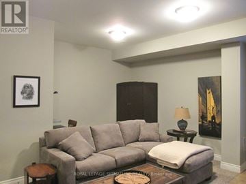 Toronto (Mimico) apartment for rent - A living room with a grey couch and a small table with a lamp on it.