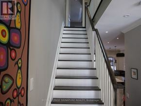 Toronto (Mimico) apartment for rent - A staircase with a metal railing and white steps.
