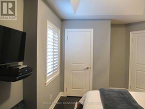 Toronto (Mimico) apartment for rent - A bedroom with a bed, a television, and a window with blinds.