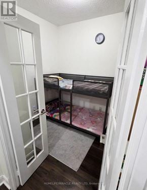 Mississauga (City Centre) condo for rent - A small bedroom with a bunk bed and a clock on the wall.