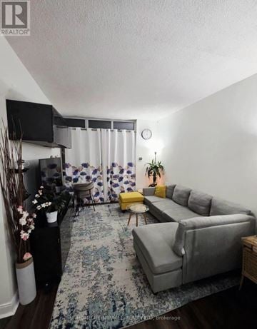 Mississauga (City Centre) condo for rent - A living room with a grey couch and a yellow ottoman.