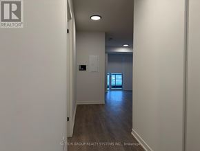 Burlington (Alton) condo for rent - A hallway with a door on the right and a light switch on the wall.