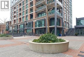 Toronto (Little Portugal) condo for rent - A modern building with a large planter in front of it.