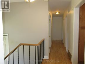 New Tecumseth (Alliston) apartment for rent - A hallway with a wooden floor and white walls.