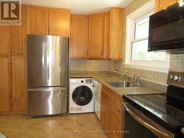New Tecumseth (Alliston) apartment for rent - A kitchen with wooden cabinets and a stainless steel refrigerator.