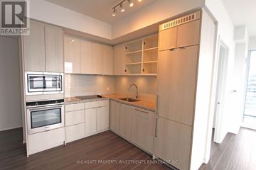 Toronto (Waterfront Communities) condo for rent - A kitchen with white cabinets and a wooden floor.