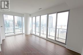 Toronto (Waterfront Communities) condo for rent - A large empty room with a view of the city.