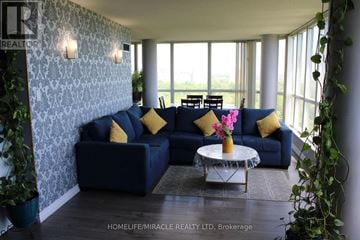 Toronto (Mount Olive-Silverstone-Jamestown) condo for rent - A living room with a blue couch and a glass coffee table.