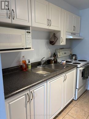 Russell condo for rent - A kitchen with white cabinets and a granite countertop.