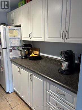 Russell condo for rent - A kitchen with white cabinets and a black counter top.