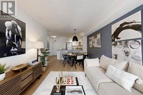 Toronto (Mount Pleasant West) condo for rent - A modern living room with a white sofa, wooden coffee table, and a dining table with chairs.