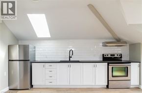 Brantford apartment for rent - A modern kitchen with white cabinets and a stainless steel refrigerator.