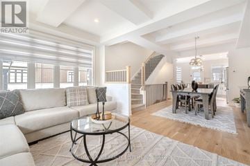 Oakville (Ro River Oaks) townhouse for rent - A modern living room with a glass coffee table and a staircase in the background.