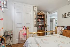 Hamilton (Huntington) apartment for rent - A bedroom with a bed, a chair, a bookshelf, and a door.