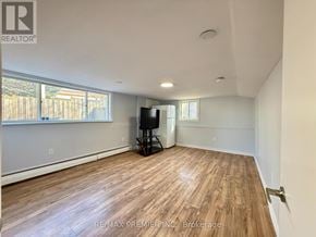St. Catharines (Fairview) apartment for rent - A spacious room with wooden flooring and a flat-screen TV.