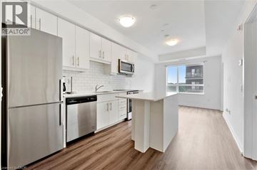 Waterloo condo for rent - A modern kitchen with white cabinets and stainless steel appliances.