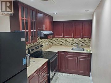 Mississauga (Meadowvale Village) apartment for rent - A kitchen with dark wood cabinets and a black refrigerator.
