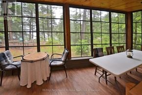 Whitestone apartment for rent - A room with a table and chairs in front of a window with a view of trees.