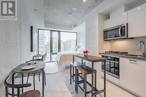 Toronto (Kensington-Chinatown) condo for rent - A modern kitchen with a dining table and chairs.