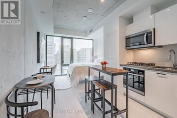 Toronto (Kensington-Chinatown) condo for rent - A modern kitchen with a dining table and chairs.