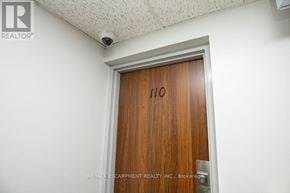 Kitchener condo for rent - A brown door with the number 110 on it.