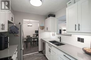 Kitchener condo for rent - A kitchen with white cabinets and a grey counter top.