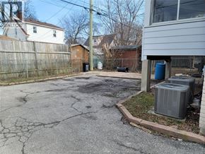 Windsor duplex for rent - A driveway with a cracked surface leads to a house.