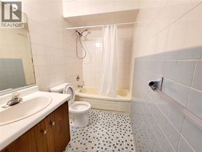 Windsor duplex for rent - A bathroom with a white toilet, sink, and bathtub.