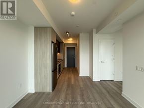 Toronto (Newtonbrook West) condo for rent - A spacious room with wood flooring and white walls.