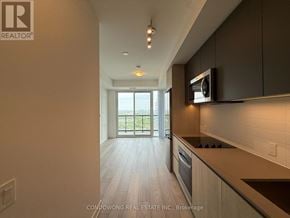 Toronto (Newtonbrook West) condo for rent - A modern kitchen with dark wood cabinets and a large window.