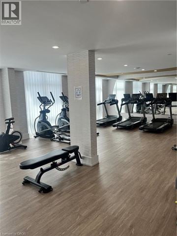 Waterdown condo for rent - A gym with a variety of equipment including treadmills, stationary bikes, and a bench.