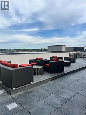 Waterdown condo for rent - A rooftop patio with black furniture and a cloudy sky.