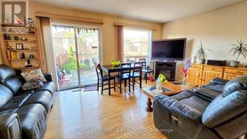 Brampton (Fletcher's Meadow) apartment for rent - A living room with a black leather couch and a wooden floor.