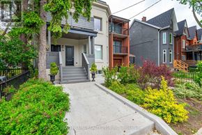 Toronto (Roncesvalles) multi-family for rent - A house with a front yard and a driveway.
