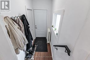 Toronto (Roncesvalles) multi-family for rent - A hallway with a coat rack and a door.
