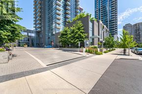 Mississauga (Hurontario) condo for rent - A view of a city street with apartment buildings and a clear blue sky.
