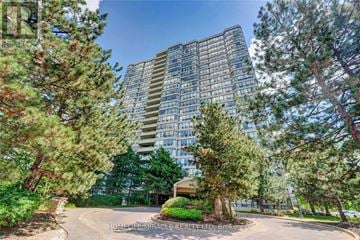 Brampton (Queen Street Corridor) condo for rent - A tall residential building surrounded by trees and a driveway.