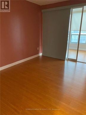 Brampton (Queen Street Corridor) condo for rent - A room with wooden flooring and a sliding glass door.