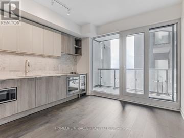 Toronto (Humewood-Cedarvale) condo for rent - A modern kitchen with wooden cabinets and a microwave.
