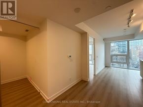 Toronto (Church-Yonge Corridor) condo for rent - A spacious room with wooden flooring and white walls, part of a real estate listing.