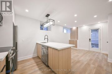 Toronto (Dufferin Grove) apartment for rent - A modern kitchen with wooden cabinets and a white countertop.