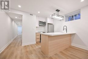 Toronto (Dufferin Grove) apartment for rent - A modern kitchen with wooden floors and a central island.