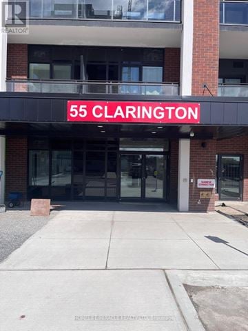 Clarington (Bowmanville) condo for rent - The front of a building with a glass door and a sign that says 55 Clarington.